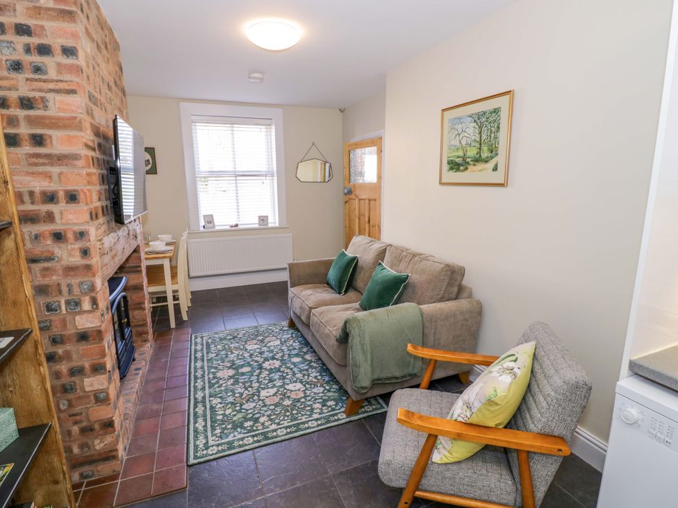 A living room with a sofa and armchair at Fern Cottage in Lichfield