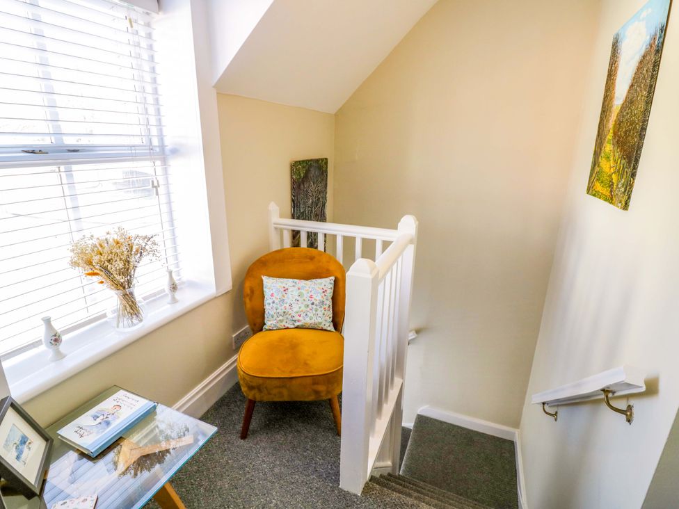A staircase with a chair and flowers at Fern Cottage in Lichfield