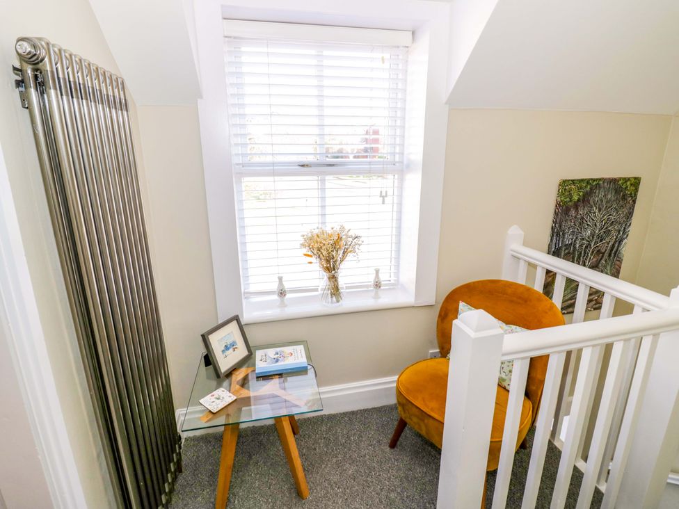 A landing area with a chair and table at Fern Cottage in Lichfield