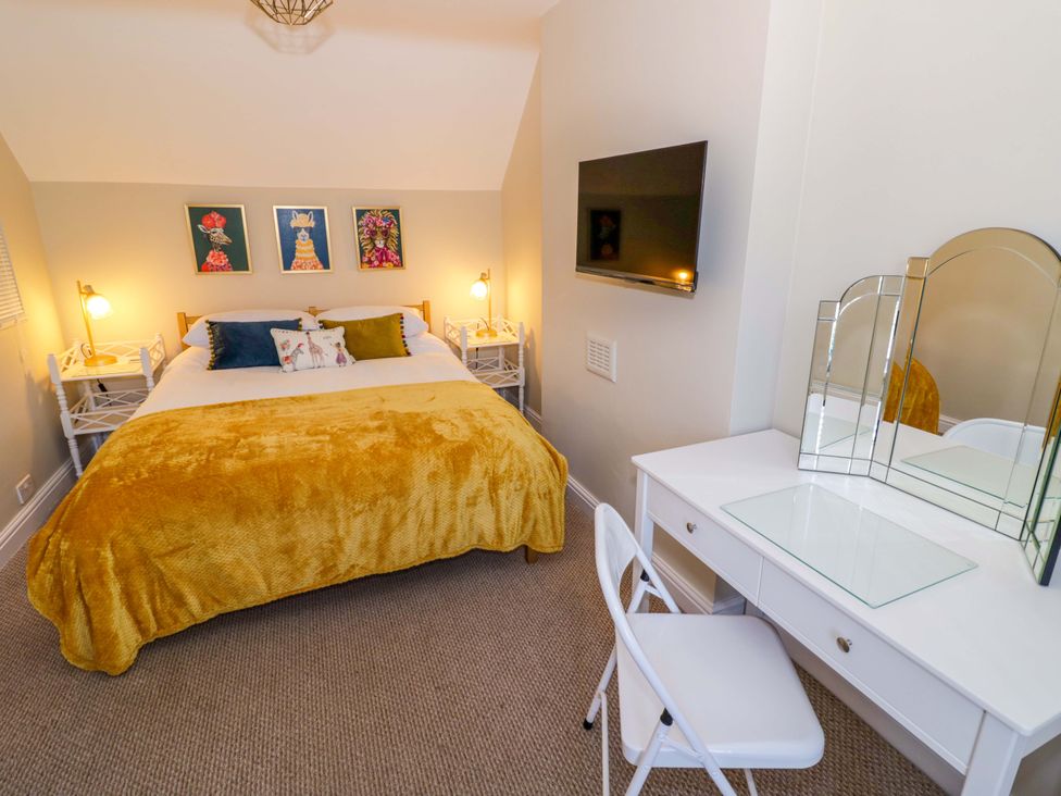 A bedroom with a bed and a vanity at Fern Cottage in Lichfield