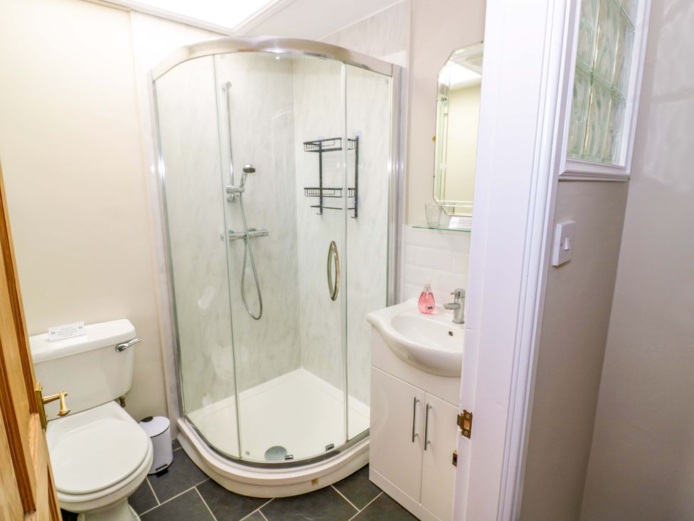 A bathroom with a shower, toilet, and sink at Fern Cottage in Lichfield