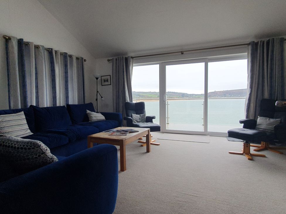 A living room with a view of the water at Gilfach Goed in Pwllheli