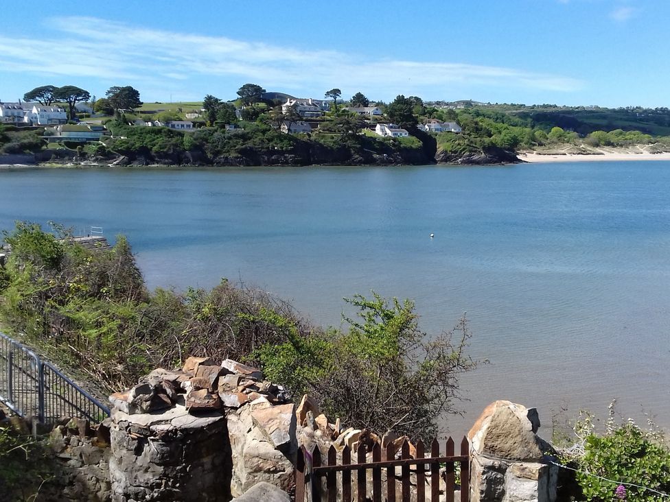 A view of water and houses across the shore at Gilfach Goed Pwllheli