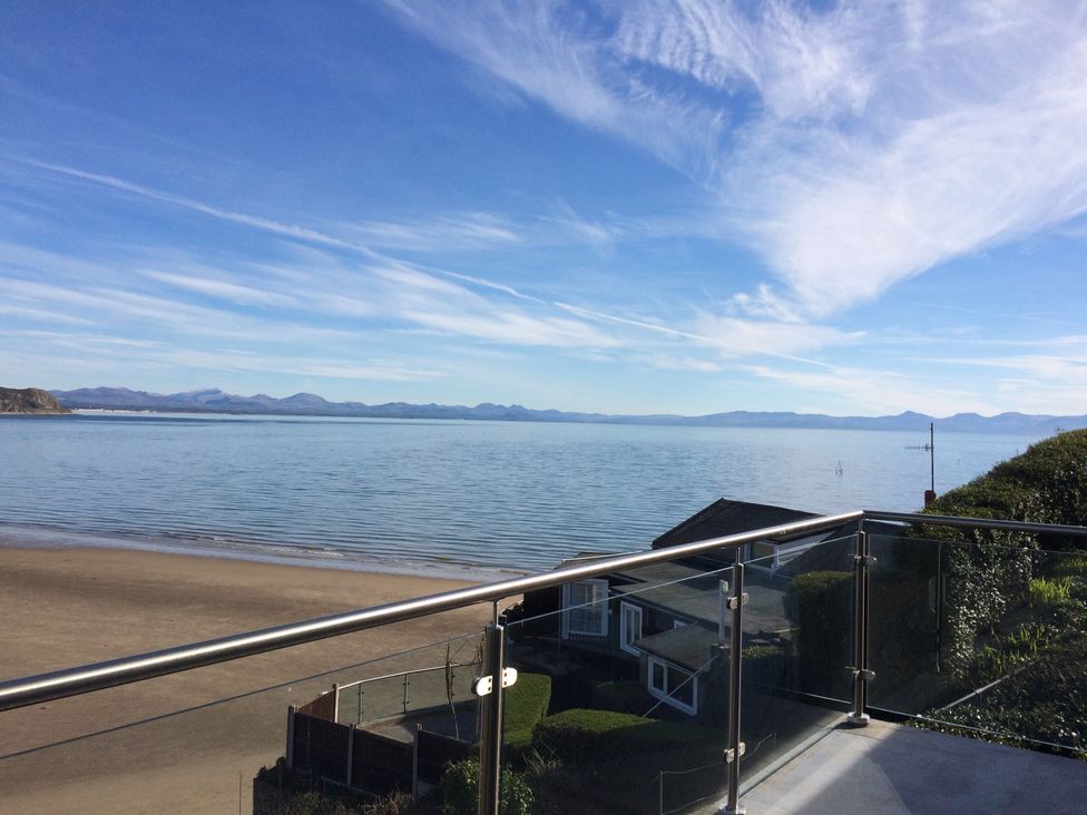 A view of the sea and mountains from a balcony at Gilfach Goed in Pwllheli