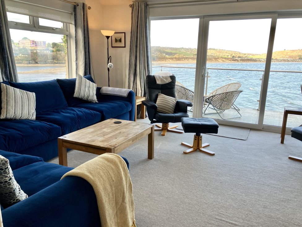 A living room with a view of water at Gilfach Goed in Abersoch