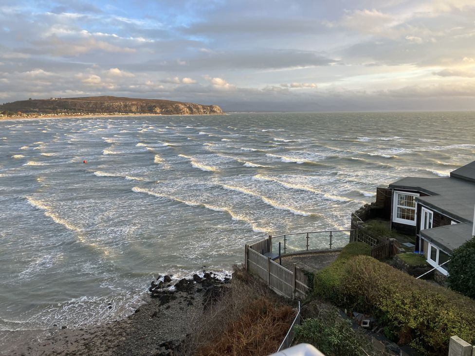 An ocean view with waves and a house at Gilfach Goed in Abersoch