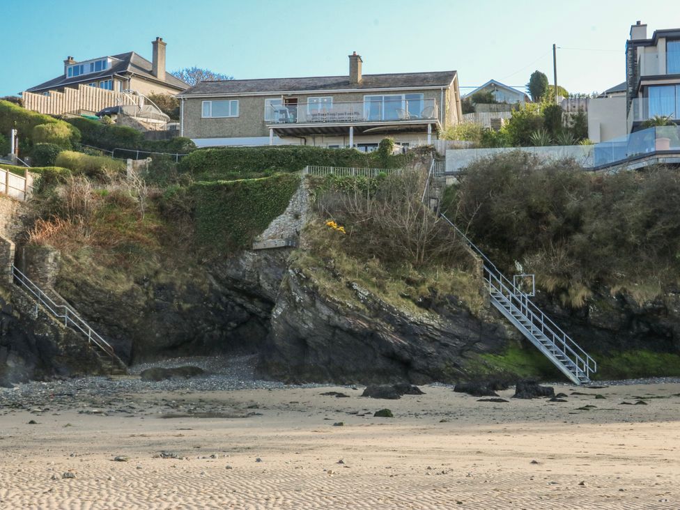 Houses on a cliff with stairs leading to the beach at Gilfach Goed Abersoch