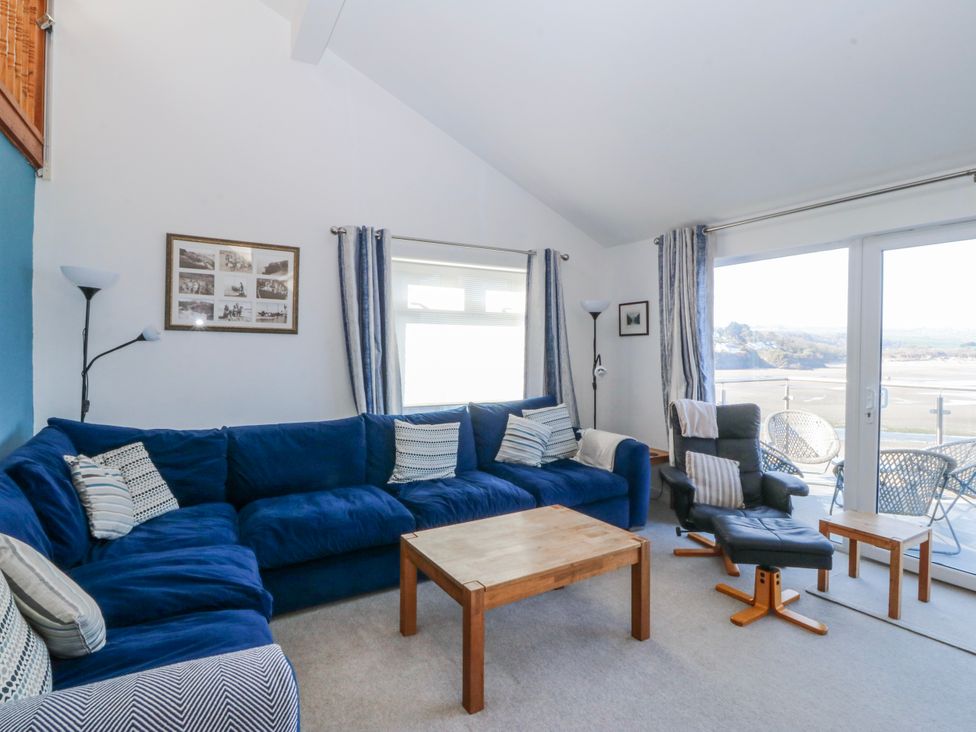 A living room with a blue sofa and coffee table at Gilfach Goed in Abersoch