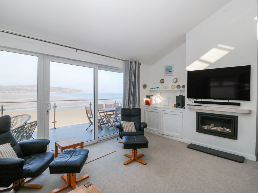 A living room with a view of the beach at Gilfach Goed in Abersoch