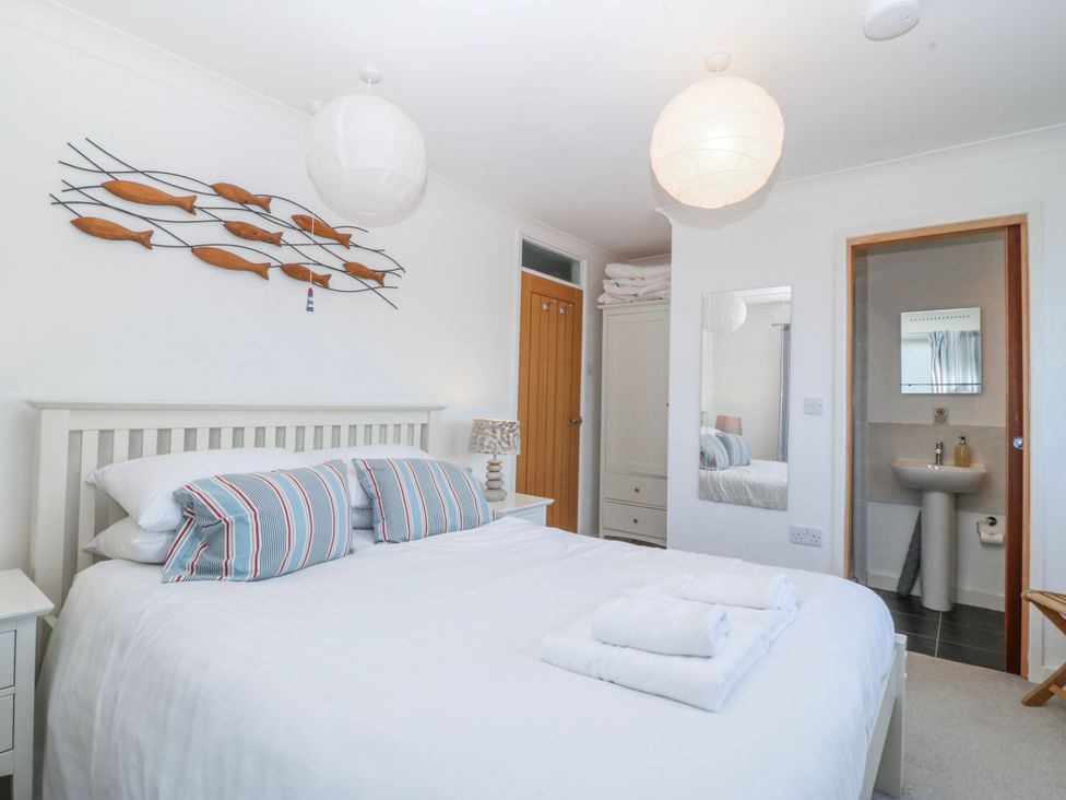 A bedroom with a bed and ensuite bathroom at Gilfach Goed Abersoch