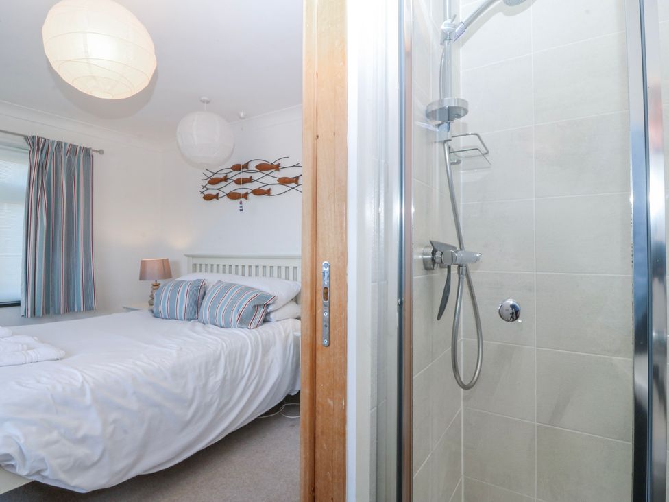 A bedroom with a bed and a shower at Gilfach Goed in Abersoch