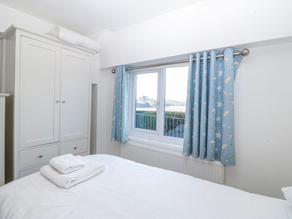 A bedroom with a bed and wardrobe at Gilfach Goed in Abersoch