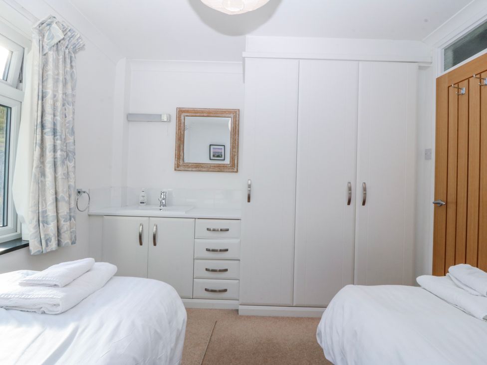 A bedroom with a bed and wardrobe at Gilfach Goed, Abersoch