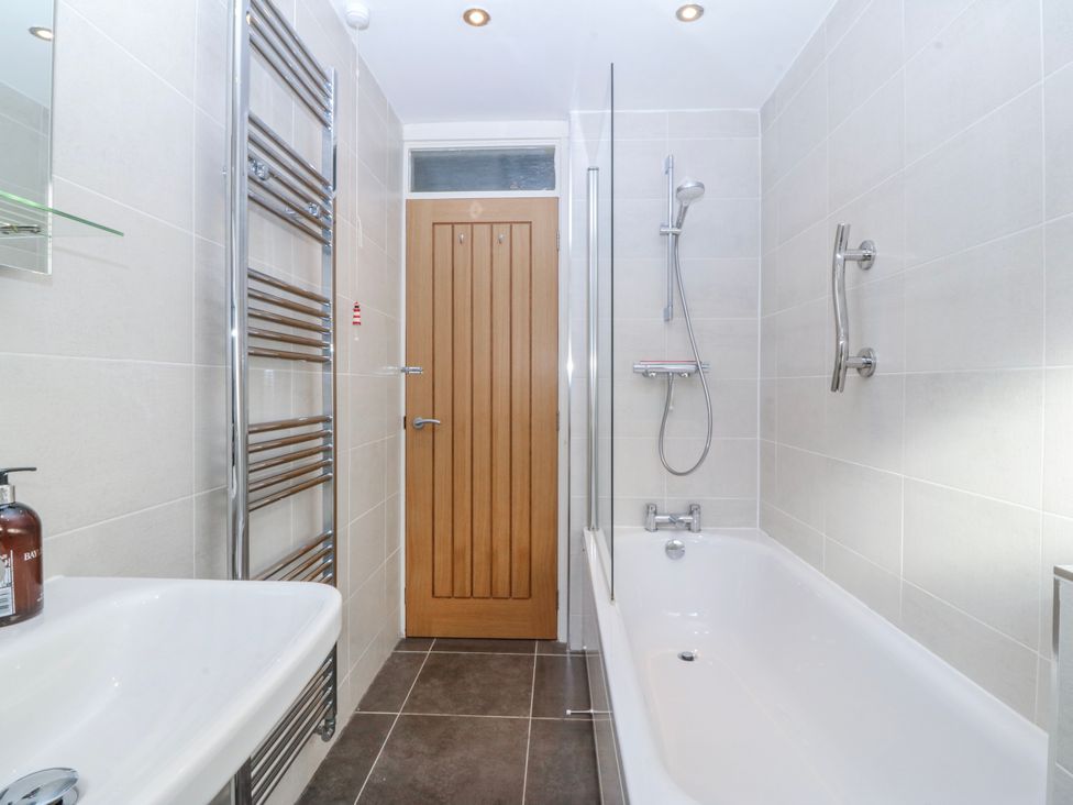 A bathroom with a bathtub and shower fixtures at Gilfach Goed in Abersoch