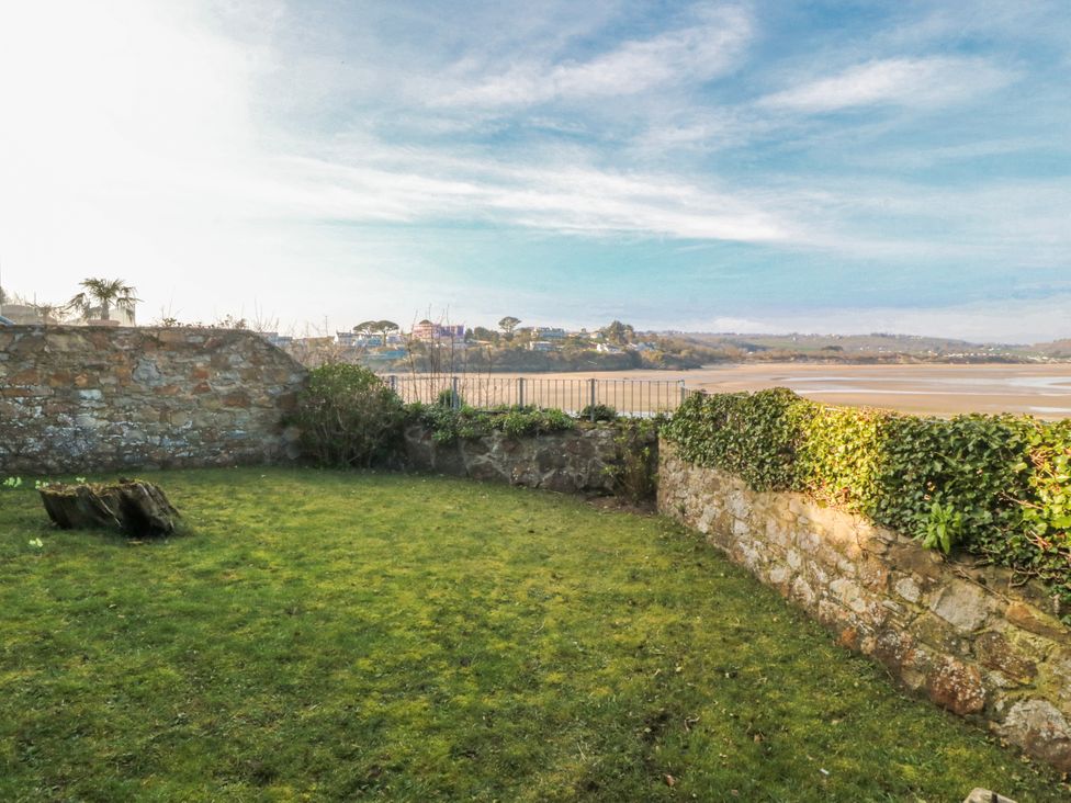 A garden with stone walls and grass at Gilfach Goed Abersoch