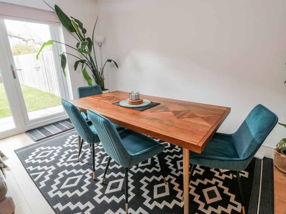 A dining room with a wooden table and chairs at 14 Old Market Place Bonnyrigg
