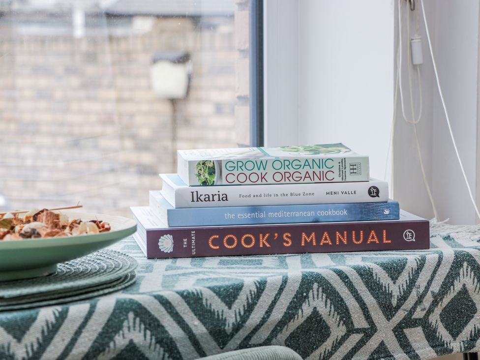 Four cookbooks and a decorative plate on a table at 14 Old Market Place Bonnyrigg