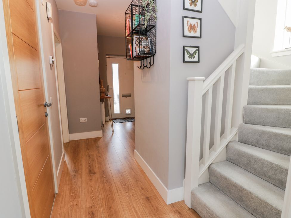 A hallway with a staircase and an entrance door at 14 Old Market Place in Bonnyrigg