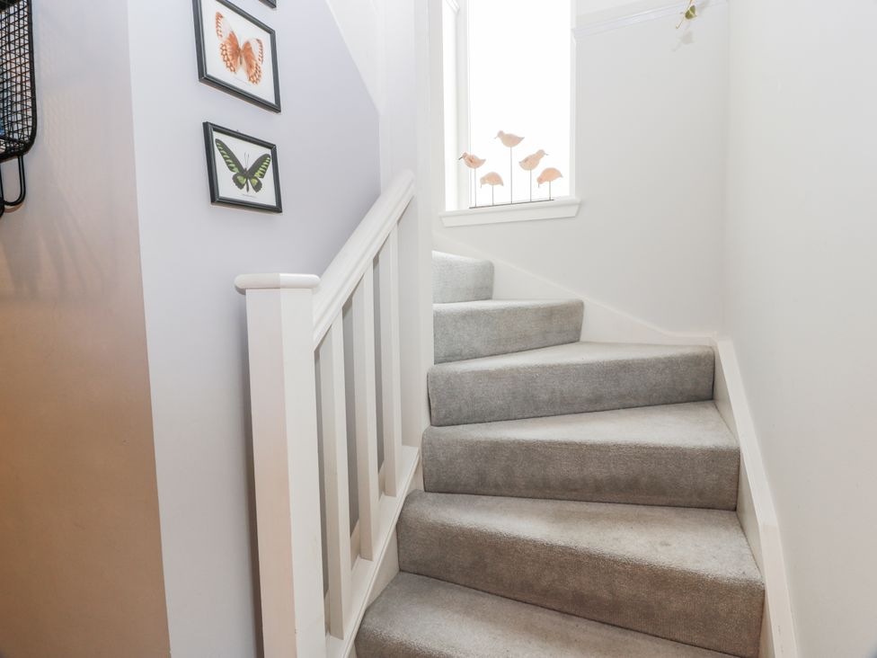 A staircase with framed pictures on the wall at 14 Old Market Place in Bonnyrigg