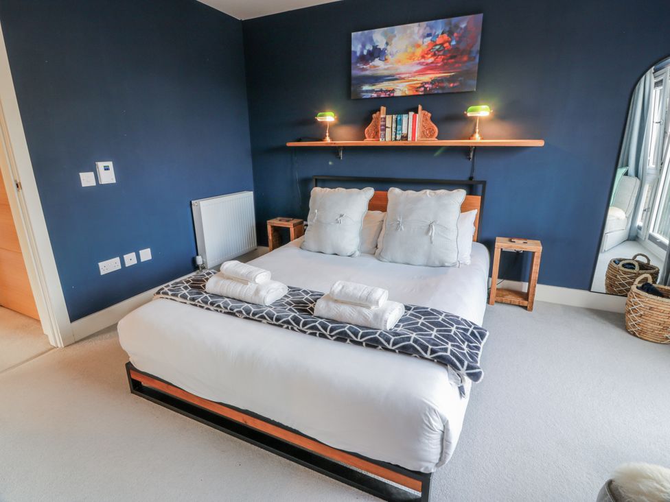 A bedroom with a bed and shelf at 14 Old Market Place in Bonnyrigg