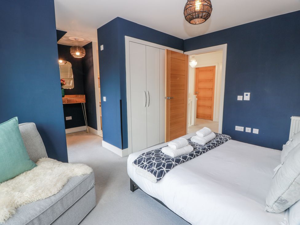 A bedroom with a bed and sofa at 14 Old Market Place in Bonnyrigg