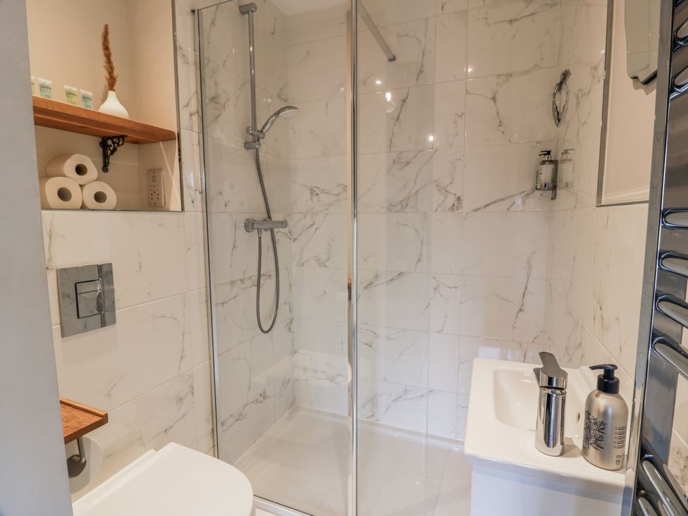 A bathroom with a shower and sink at 14 Old Market Place Bonnyrigg