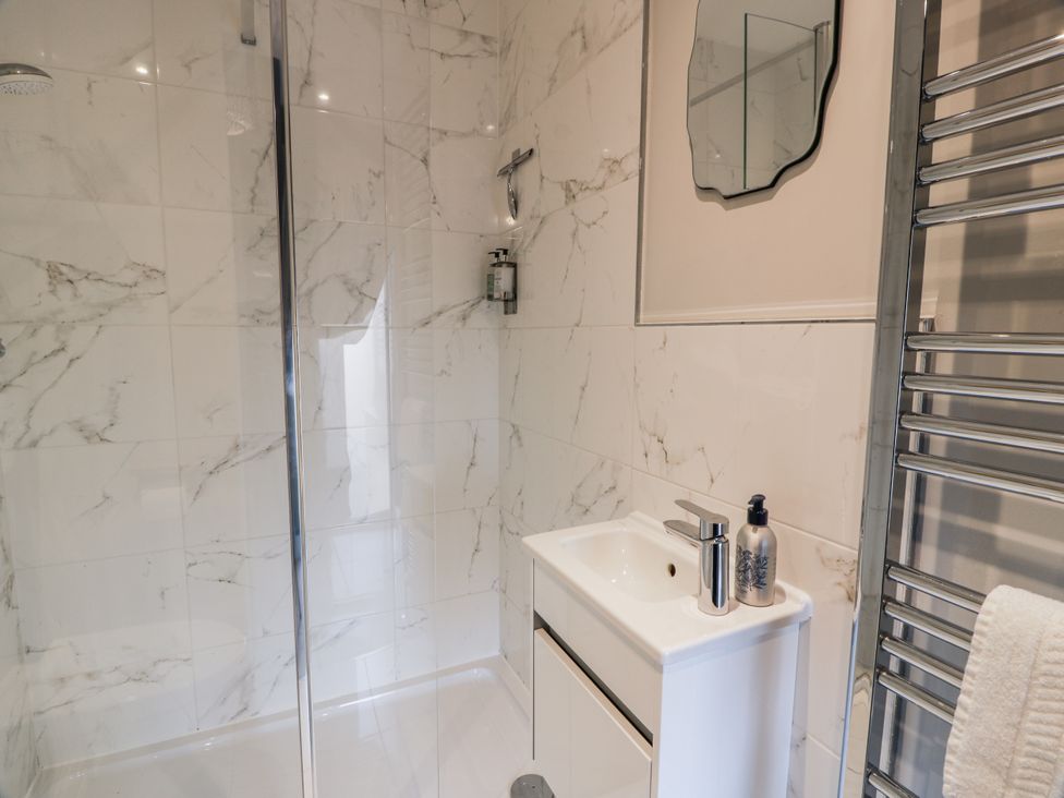 A bathroom with a shower and sink at 14 Old Market Place in Bonnyrigg