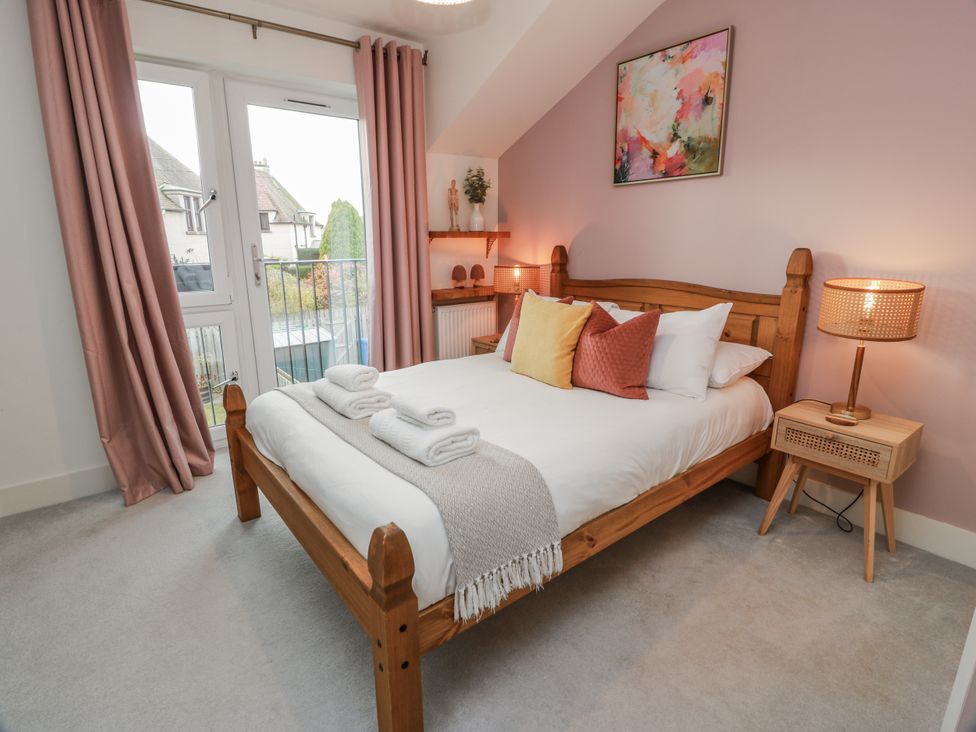 A bedroom with a bed and bedside table at 14 Old Market Place Bonnyrigg