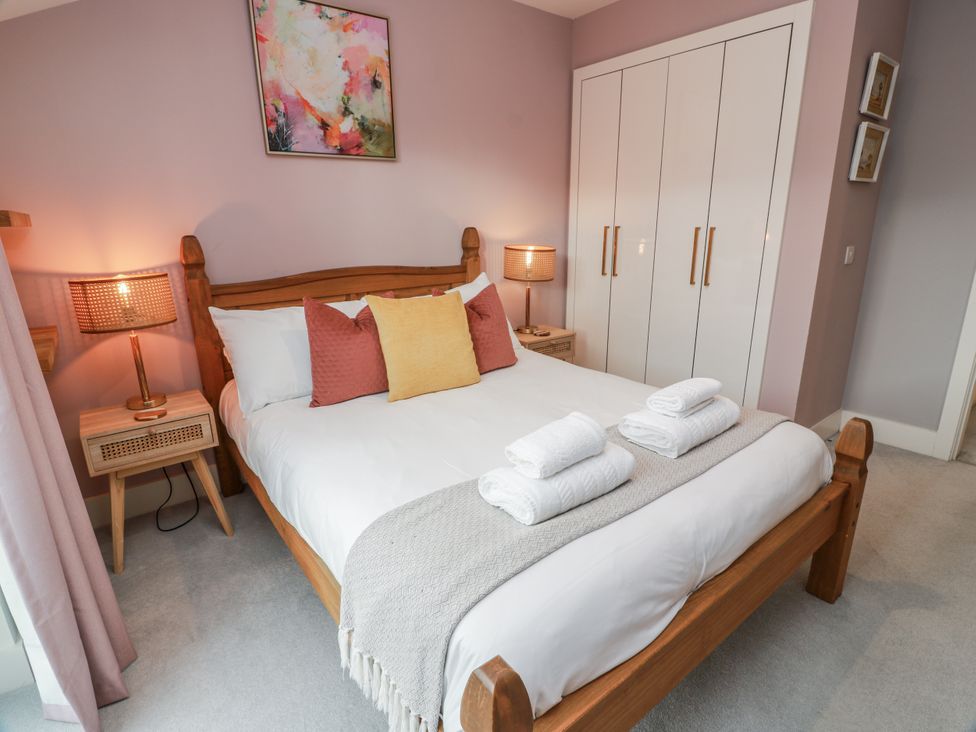 A bedroom with a bed and nightstand at 14 Old Market Place in Bonnyrigg