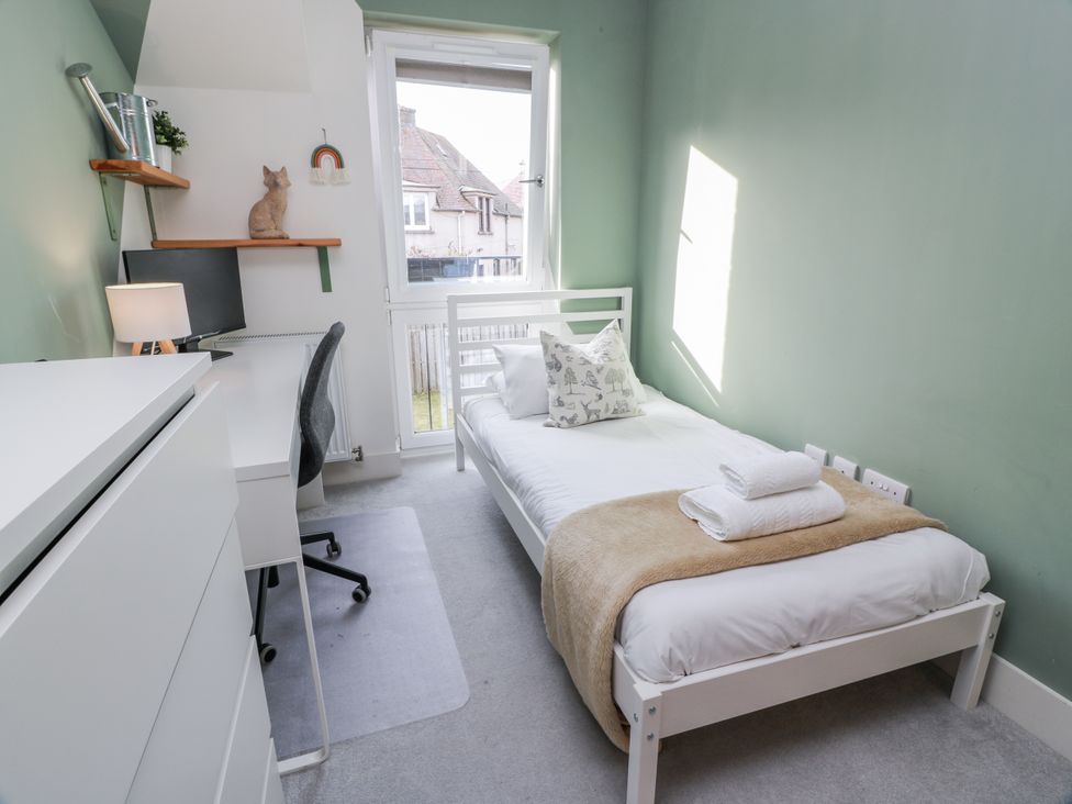 A bedroom with a bed and desk at 14 Old Market Place Bonnyrigg