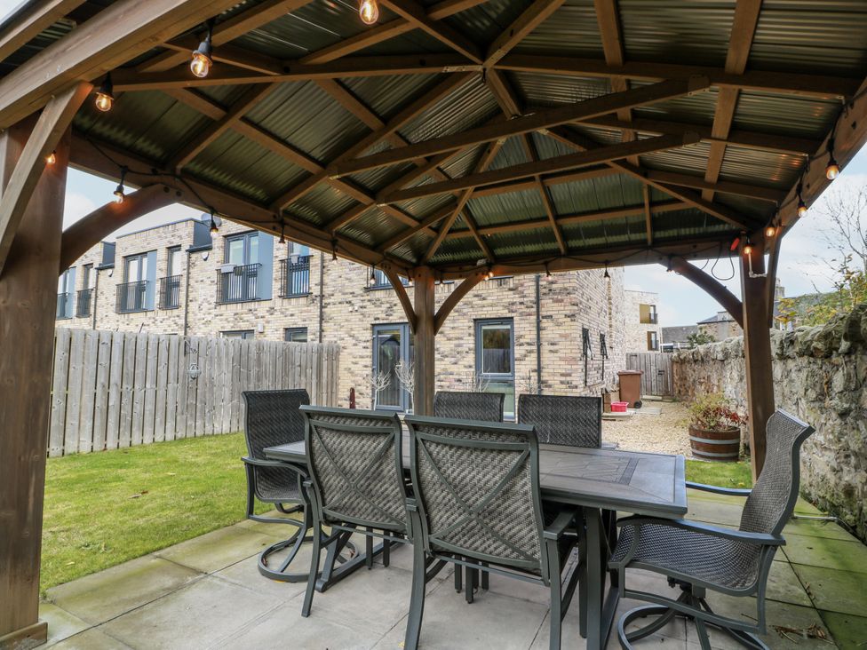 A gazebo with table and chairs in a garden at 14 Old Market Place Bonnyrigg