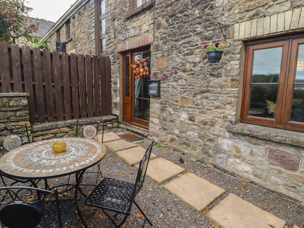An outdoor seating area with a table and chairs at Gwyn Studio in Aberdare
