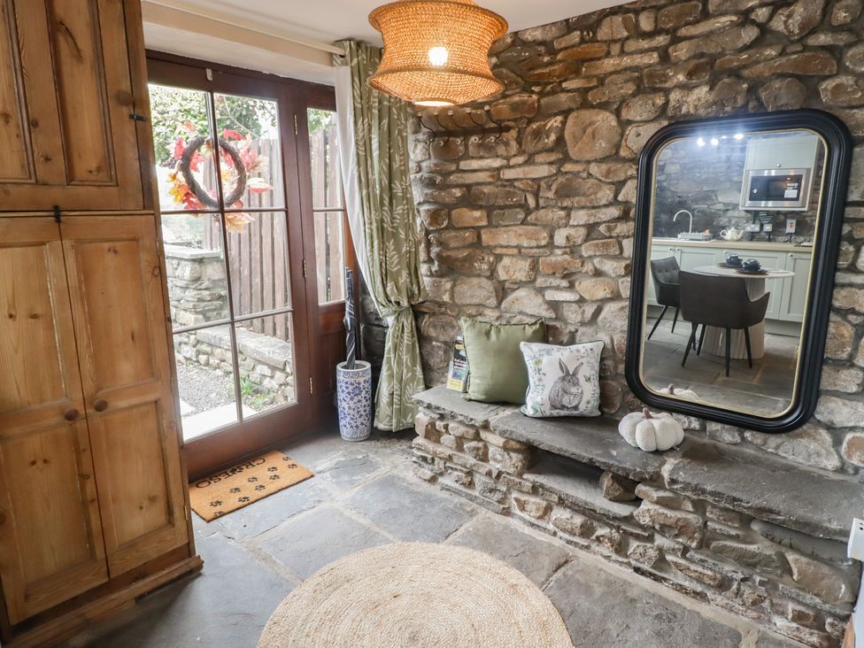 An entrance with a stone wall and door at Gwyn Studio in Aberdare