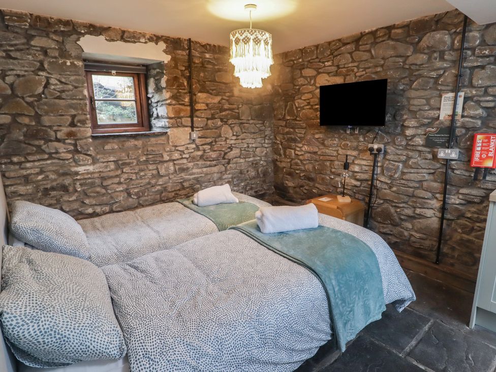A bedroom with two beds and a television at Gwyn Studio in Aberdare