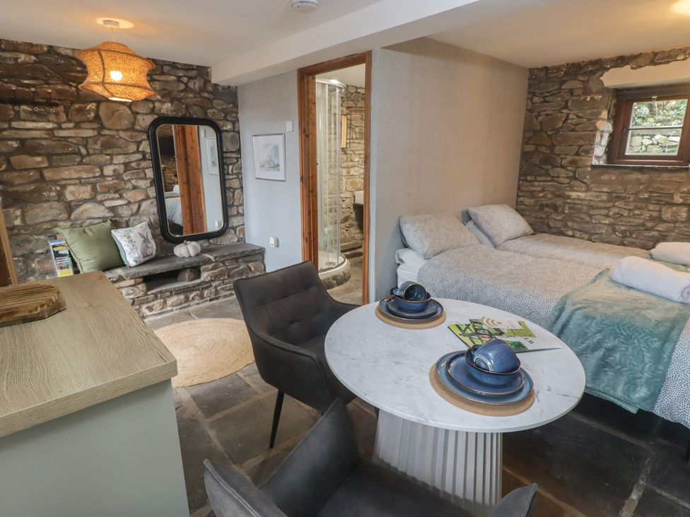 A studio with a bed and dining area in Gwyn Studio Aberdare