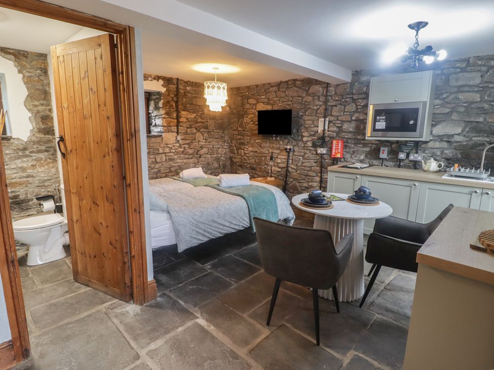 A studio room with a bed, kitchenette and dining area at Gwyn Studio in Aberdare
