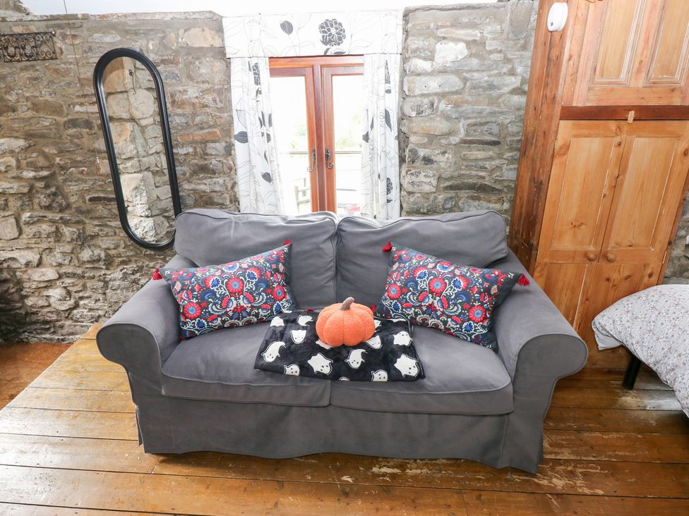 A living room with a sofa and decorative pillows at Glas Studio in Aberdare