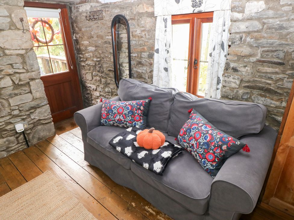 A living room with a sofa and cushions at Glas Studio in Aberdare
