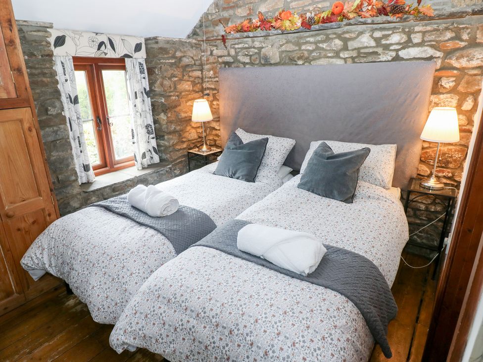 A bedroom with twin beds and a window at Glas Studio in Aberdare