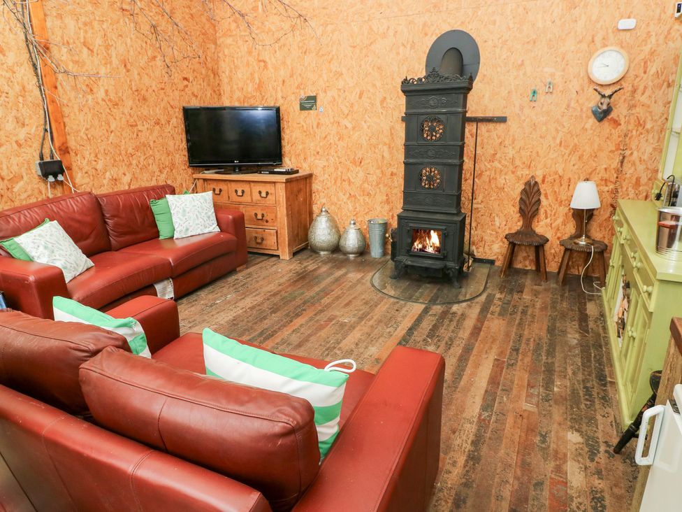 A living room with a fireplace and television at Glas Studio in Aberdare