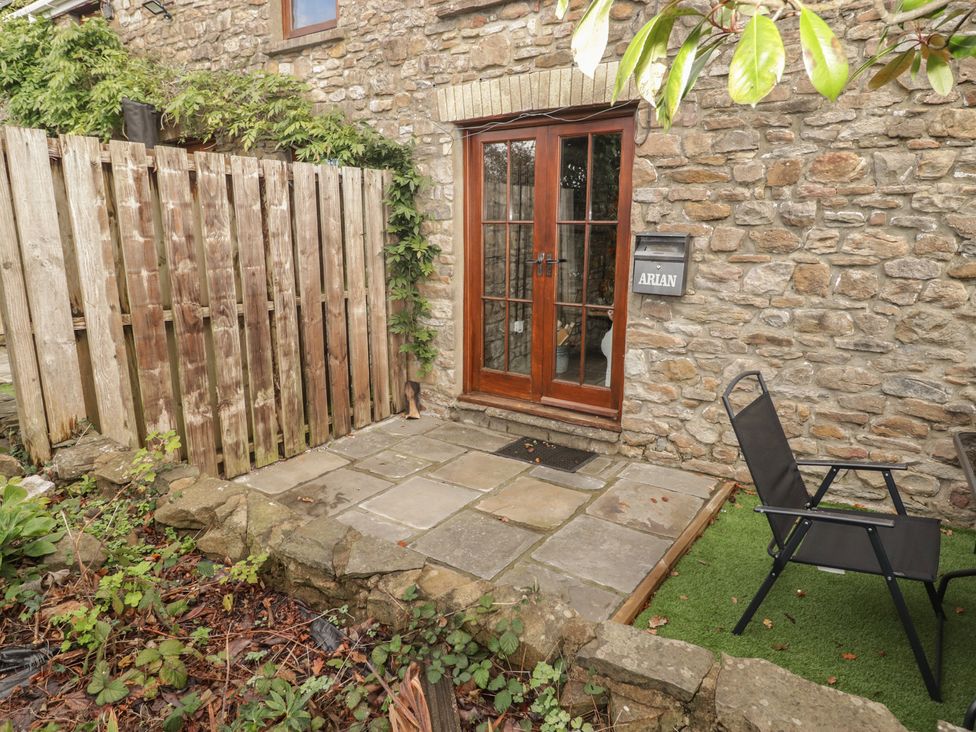 An outdoor patio area with a door and a chair at Arian in Aberdare