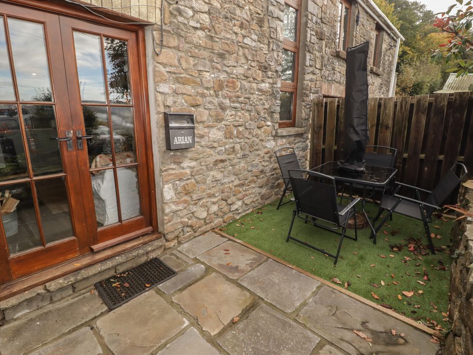 An outdoor seating area with a table and chairs at Arian in Aberdare