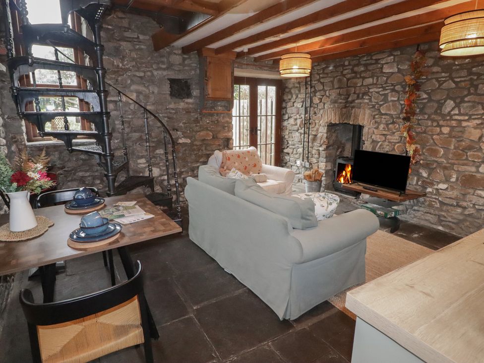 A living room with a fireplace and staircase at Arian in Aberdare