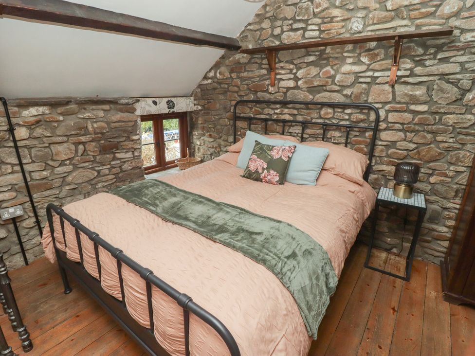 A bedroom with a bed and side table at Arian in Aberdare