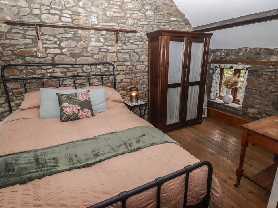 A bedroom with a bed and wardrobe at Arian in Aberdare