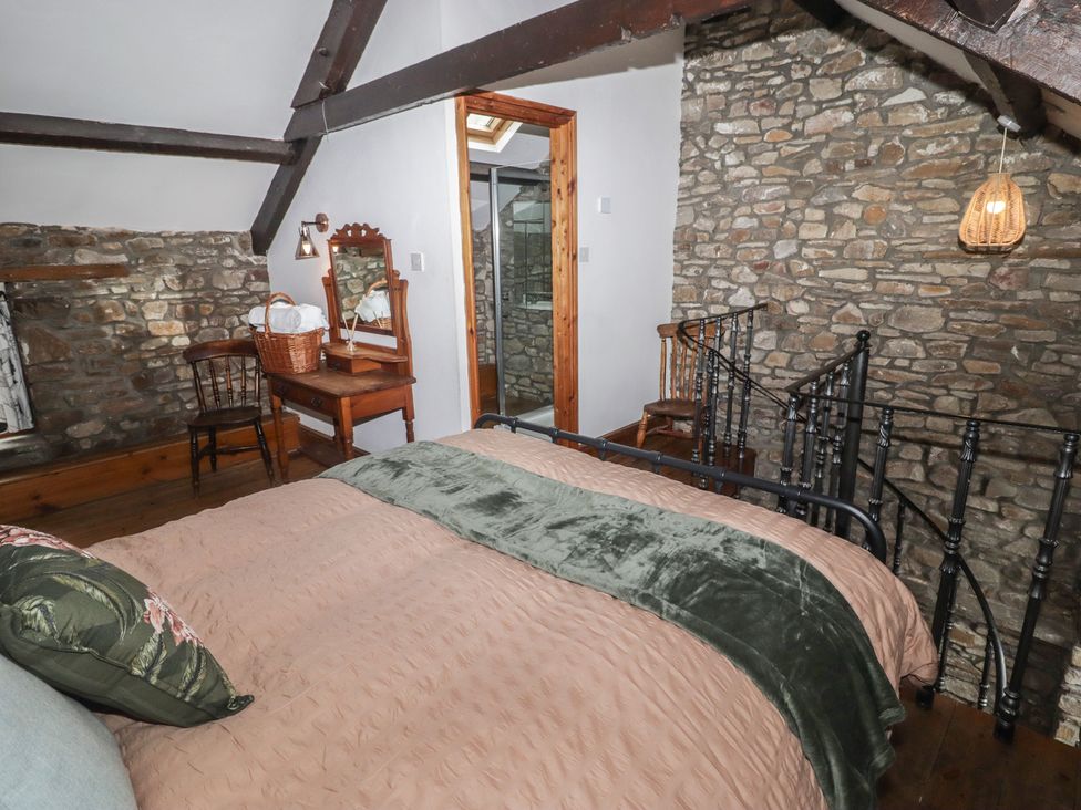 A bedroom with a bed, chair, and table at Arian in Aberdare