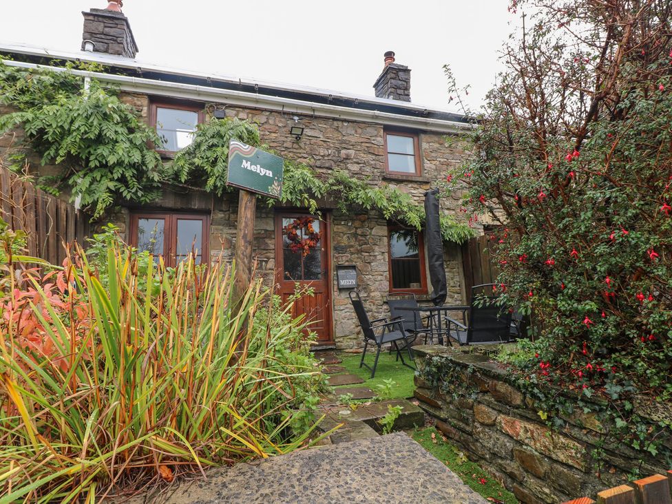 A stone house with a sign in front at Melyn in Aberdare
