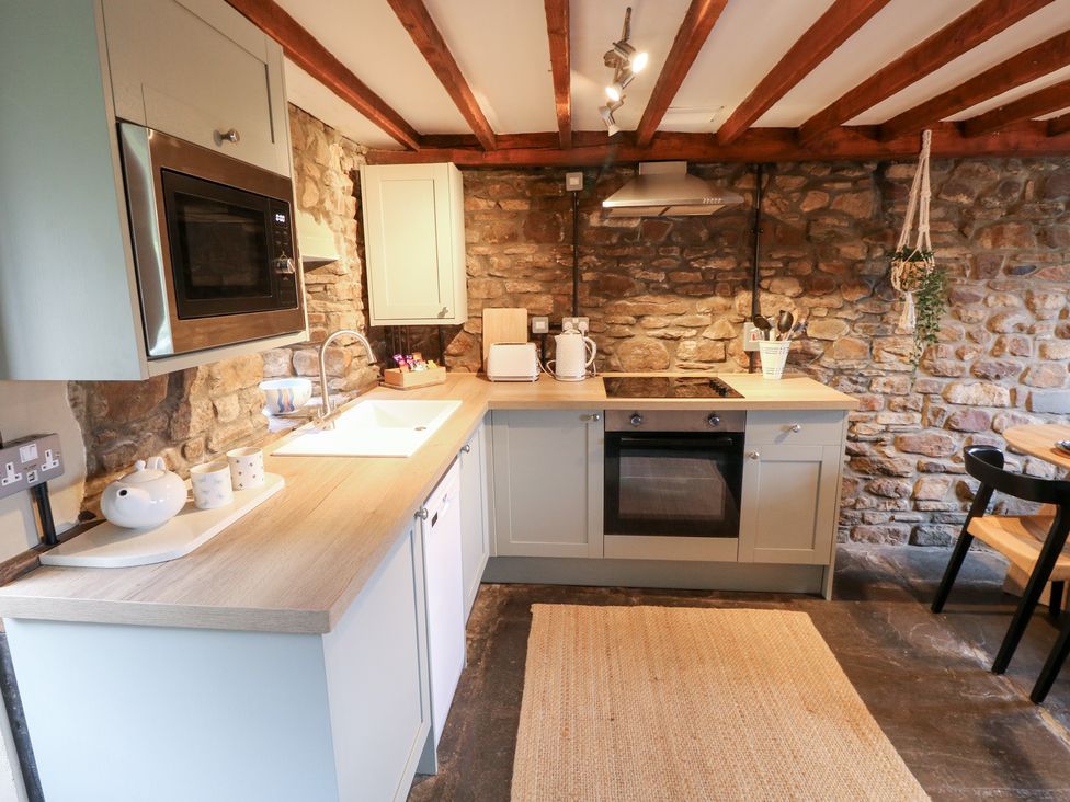 A kitchen with appliances and stone wall at Melyn in Aberdare