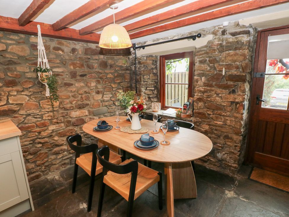 A dining room with a round table and chairs at Melyn in Aberdare