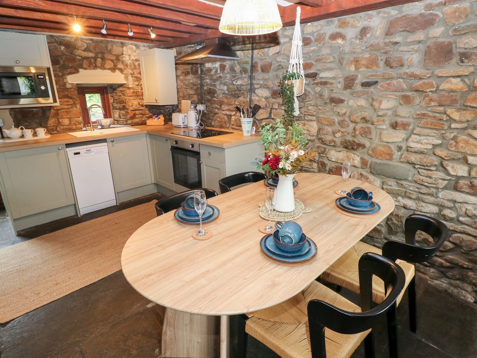 A kitchen with a dining table and chairs at Melyn in Aberdare